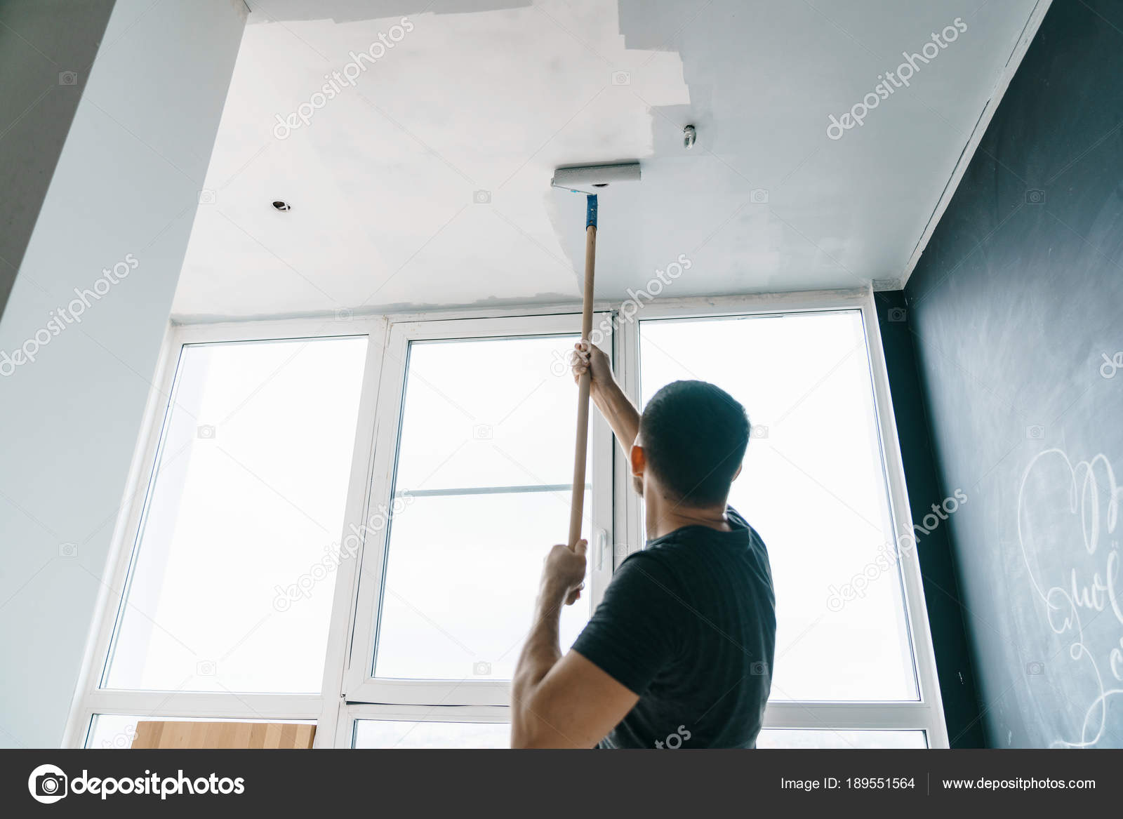 Man Paints Walls Ceiling Gray Color Standing His Back Camera