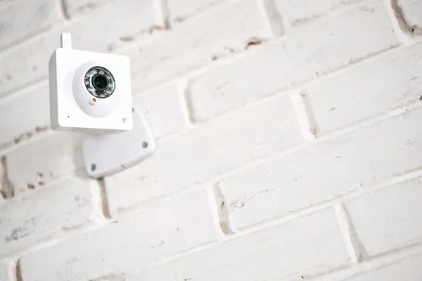 Online camera on a brick wall. Technology of observation and safety.