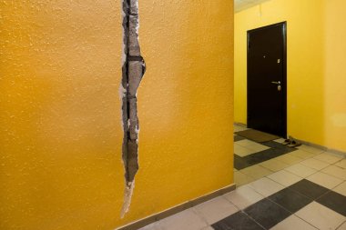 Apartmanın duvarında bir çatlak. Sarı duvar girişi. Belediye Konut sorunu.