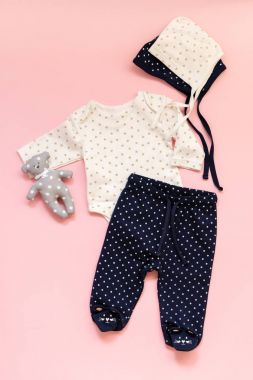 bir kız için çocuk giyim pembe bir arka plan üzerinde bir dizi: pantolon, vücut ve büyük harf seçenekleri