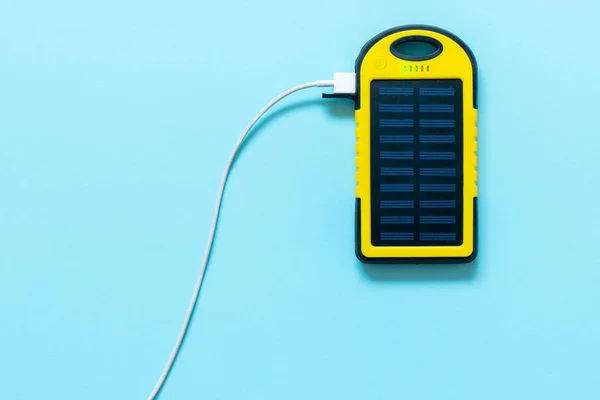 Yellow Battery Solar Power Device Blue Background Charge Smartphone Solar — Stock Photo, Image