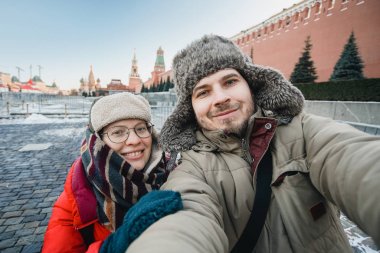 Kızıl Meydan, Moskova, Rusya'nın seyahat Kremlin önünde kendi portresi selfie turistlerin kışın sıcak giysiler içinde mutlu Romantik Çift yapar