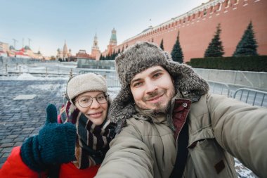 Kızıl Meydan, Moskova, Rusya'nın seyahat Kremlin önünde kendi portresi selfie turistlerin kışın sıcak giysiler ve şapkalar mutlu Romantik Çift yapar.