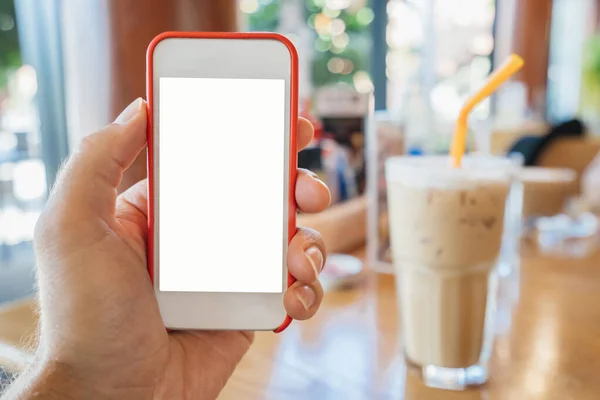 Макет самртфона в мужской руке белый в красной рамке, на фоне кафе и холодного напитка — стоковое фото