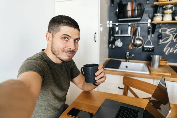 Hombre Guapo Tomando Selfie Mientras Trabaja Ordenador Portátil Casa Cocina — Foto de Stock