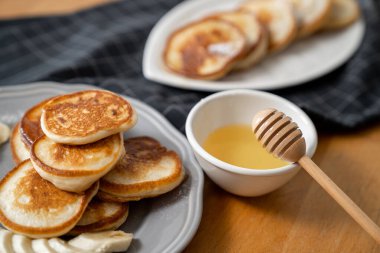 Akçaağaç şuruplu leziz taze krepler ya da tahta çubuklu arı balı bal..