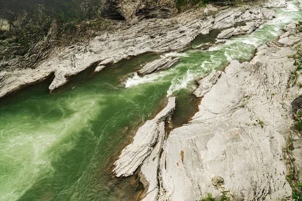 Yukarıdan muhteşem bir dağ nehri manzarası. Kayalık kıyılar ve yeşil su.