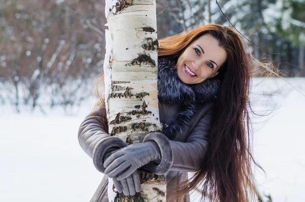 Веселая женщина в зимнем лесу — стоковое фото