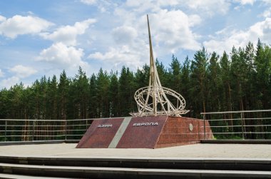EKATERINBURG, RUSSIA - JULY 16, 2014: The monument on the border of Europe and Asia on a Sunny summer day near the city of Ekaterinburg clipart