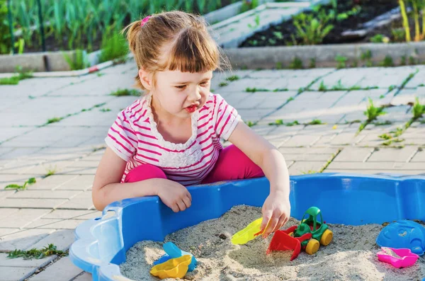 Niña jugando en una caja de arena — Foto de Stock