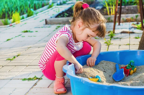 Niña jugando en una caja de arena — Foto de Stock