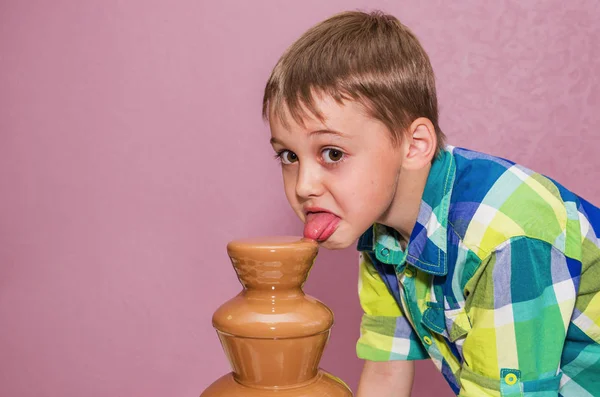 Lycklig pojke med choklad fontän — Stockfoto