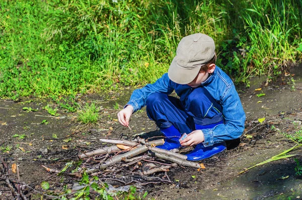 Jongen licht een brand in het bos — Stockfoto