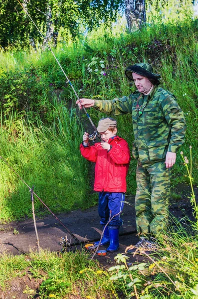 Padre enseña a su hijo a pescar —  Fotos de Stock