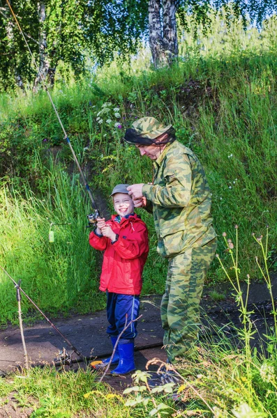 Padre enseña a su hijo a pescar — Foto de Stock