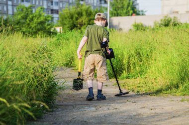 Bir metal dedektörü ile küçük çocuk