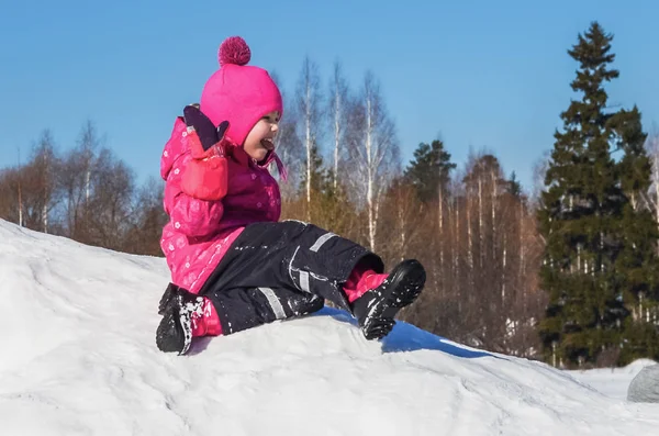 Glad liten flicka på en promenad en klar vinterdag. — Stockfoto