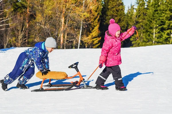 Les enfants roulent sur un scooter de neige — Photo