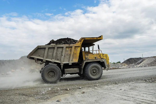 Belaz トラックは未舗装の道路で石を運ぶ — ストック写真