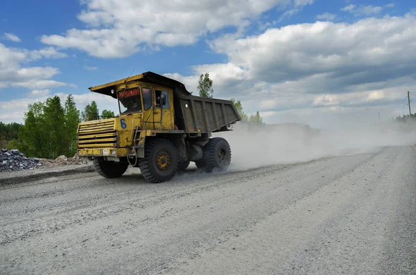 Belaz トラックは未舗装の道路で石を運ぶ — ストック写真