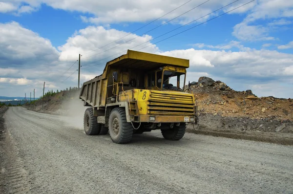 Belaz トラックは未舗装の道路で石を運ぶ — ストック写真