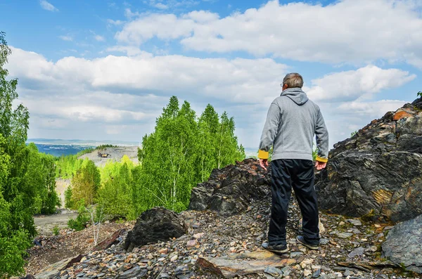 Postarší turista stojí na vrcholu hory — Stock fotografie