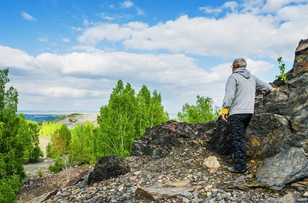 Een bejaarde toeristische staat op de top van de berg — Stockfoto