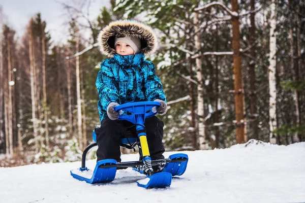 Liten pojke på snöskoter — Stockfoto