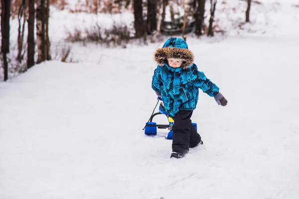 Boy with snow-scooter on a winter walk. — Stock Photo, Image