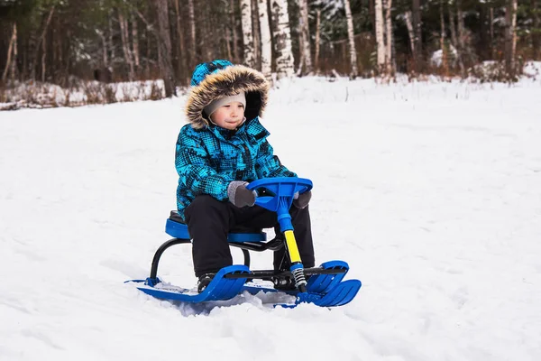 Garçon chevauche un scooter de neige — Photo