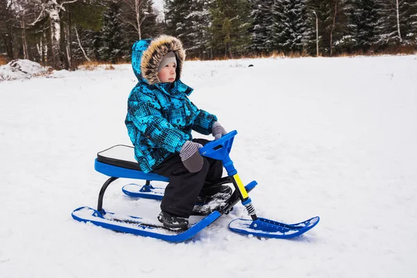 Garçon chevauche un scooter de neige — Photo