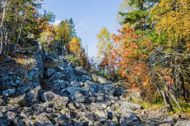 Bir dağın tepesinde kayalar olan sonbahar manzarası