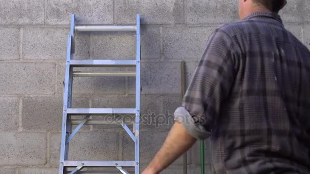 Homem leva escada para fora ao ar livre — Vídeo de Stock