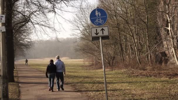 Paar läuft im Park von Schild weg — Stockvideo