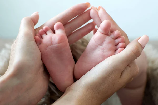 Bebek bacakları annenin ellerinde. — Stok fotoğraf