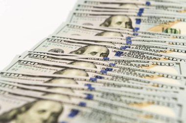 Beyaz yüzeyine yayılmış birçok yüz dolarlık banknot