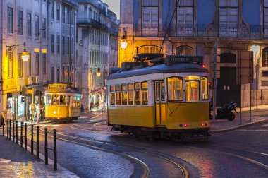 Tramvaylar karşıdan karşıya geçerken akşam saatlerinde Lizbon, Portekiz
