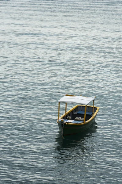 Piccola barca ancorata vicino alla riva sul mare calmo — Foto Stock
