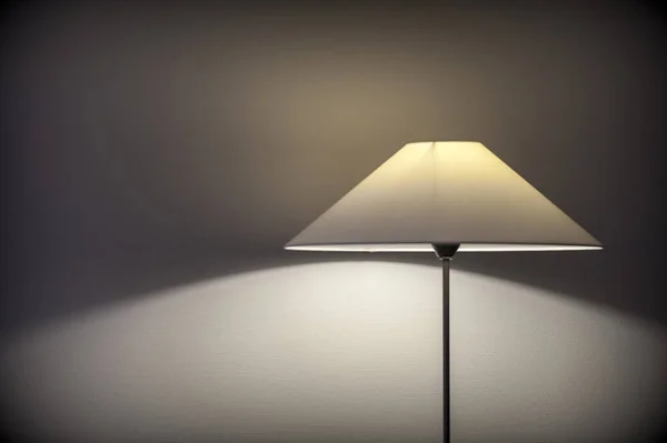 Lámpara de habitación de hotel proyectando luz y sombra en la pared Fotos de stock