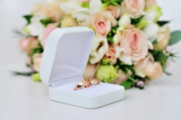 Anéis de casamento e buquê de rosas — Fotografia de Stock