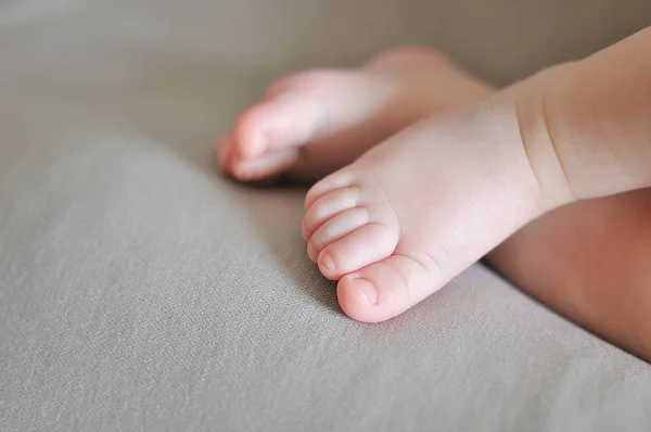 Primer plano de diminutos adorables pies desnudos de bebé de color rosa —  Fotos de Stock