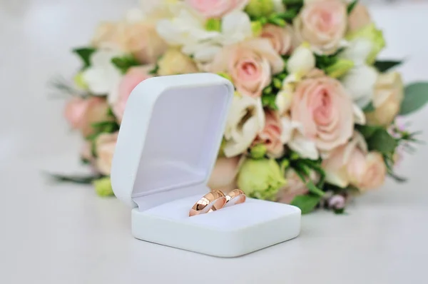 Ramo de boda sobre anillos de boda — Foto de Stock