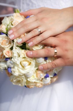 Düğün buketi ve altın ile gelin ve damat ellerini yakın