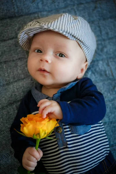 Αγόρι κρατά ένα κίτρινο τριαντάφυλλο στο χέρι στο στούντιο — Φωτογραφία Αρχείου