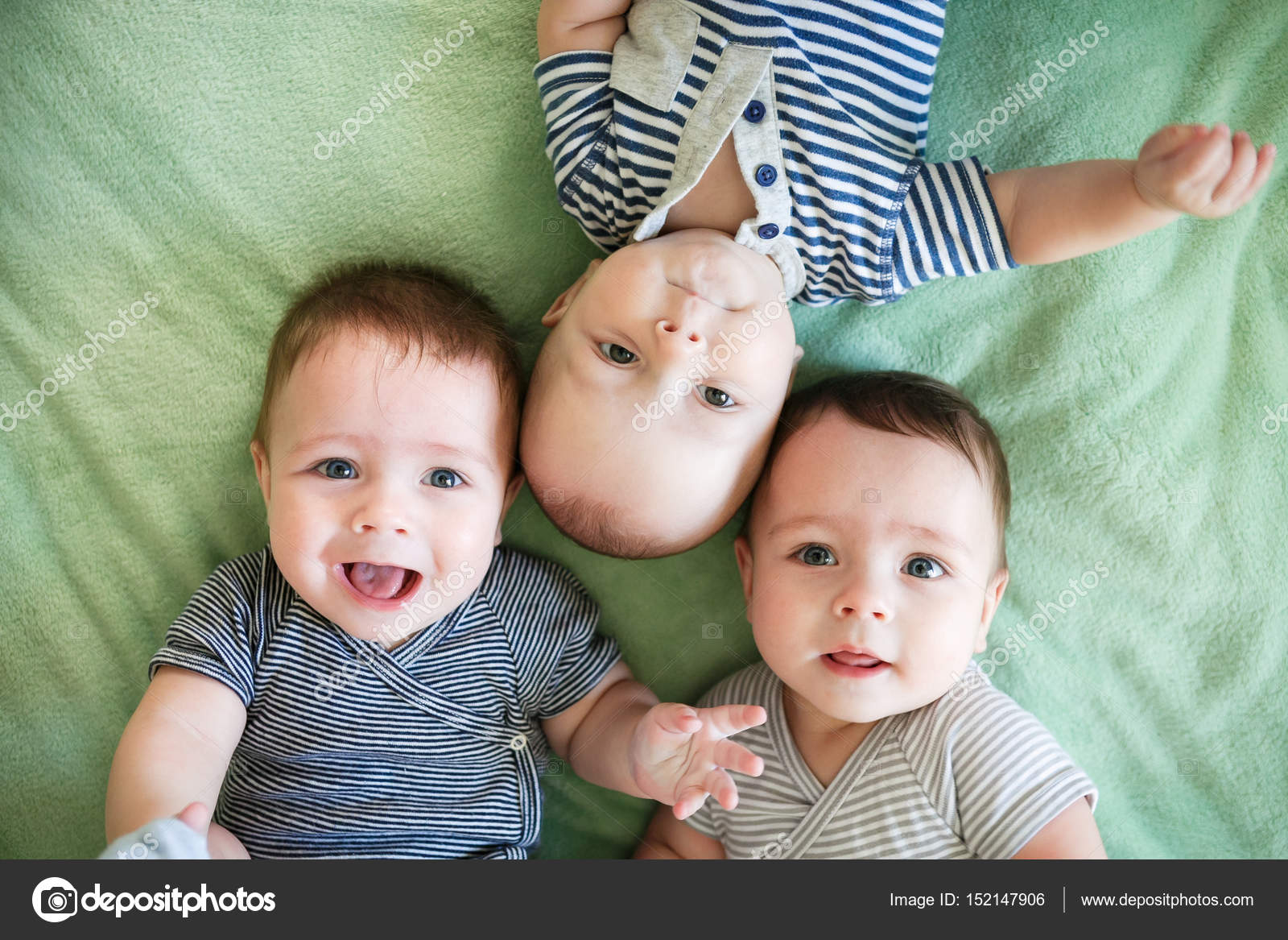 Portrait of newborn triplets are lying in the bed — Stock Photo