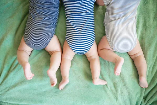 Az újszülött hármasok hason fekszenek egy takarón. — Stock Fotó