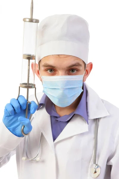 Ritratto del medico in maschera con la siringa grande isolata o — Foto Stock