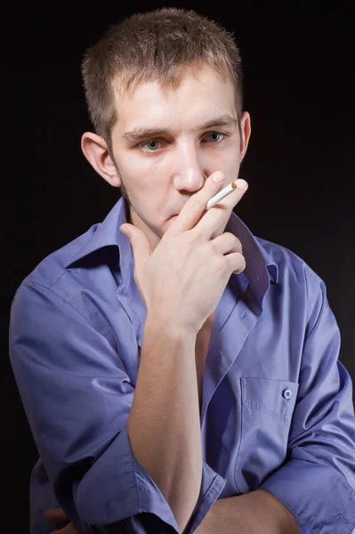 Porträt eines Mannes, der im Studio raucht Stockbild