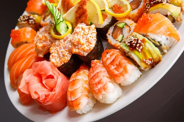Maki, uramaki y nigiri sushi servidos en plato blanco de cerca — Foto de Stock
