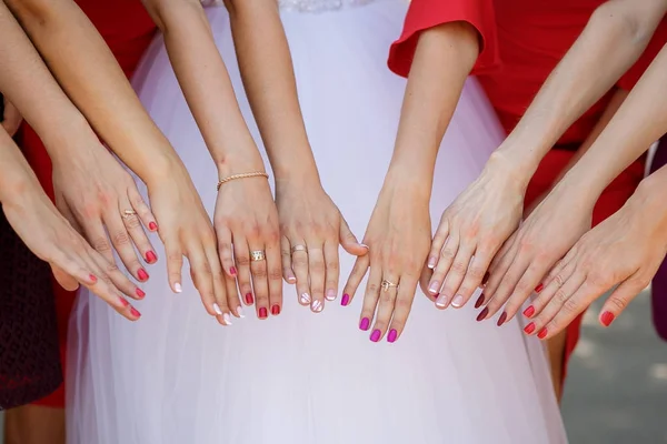 Bride and her girlfriends stand side by side and show the bouquets in their hands. — Stock Photo, Image